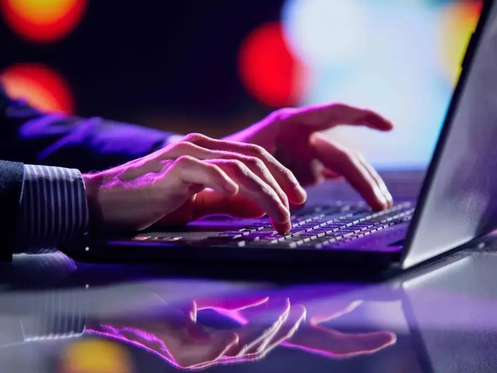 a close-up of a person typing on a laptop